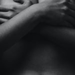 grayscale photo of woman covering her breast using her both hands